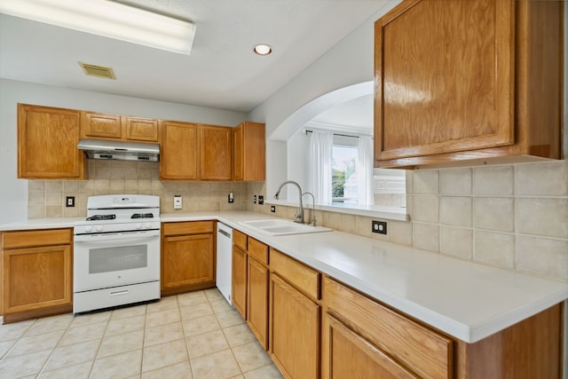 19710 Ringwald Ct, Spring, TX 77379 - kitchen featuring white appliances, a sink, under cabinet range hood, light countertops, and arched walkways