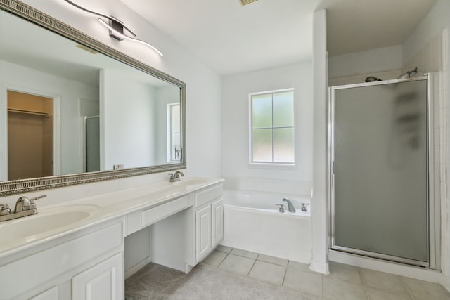 19710 Ringwald Ct, Spring, TX 77379 - bathroom featuring a stall shower, double vanity, a bath, a walk in closet, and tile patterned floors