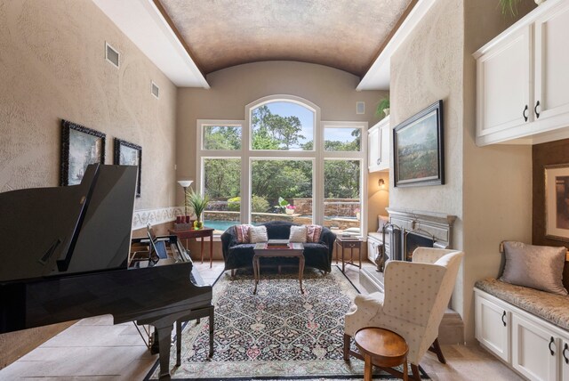 63 N Wooded Brook Cir, The Woodlands, TX 77382 - living area with a fireplace, lofted ceiling, and a textured wall