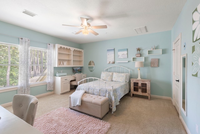 63 N Wooded Brook Cir, The Woodlands, TX 77382 - bedroom with light carpet, baseboards, a ceiling fan, and a textured ceiling