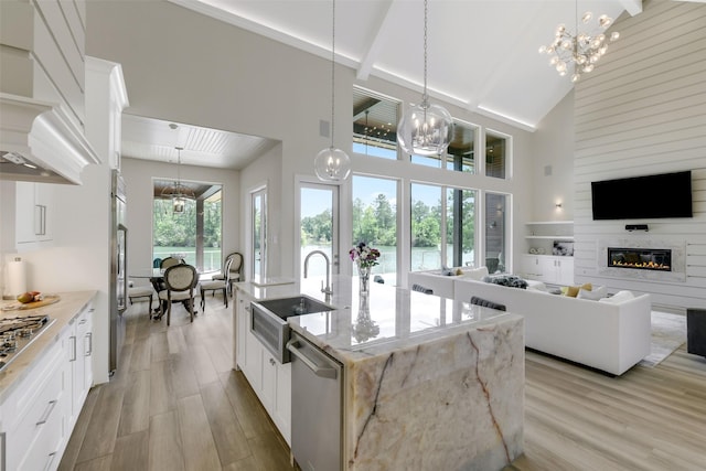 18 N Smith Loop N, Cleveland, TX 77327 - kitchen featuring a sink, high vaulted ceiling, beamed ceiling, light wood finished floors, and a glass covered fireplace