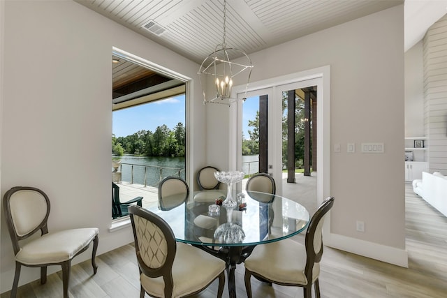 18 N Smith Loop N, Cleveland, TX 77327 - dining space featuring a chandelier, a water view, light wood-type flooring, wood ceiling, and baseboards