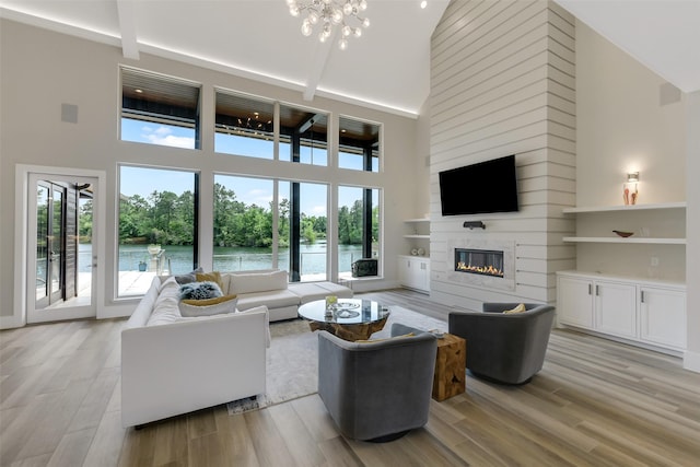 18 N Smith Loop N, Cleveland, TX 77327 - living room with a towering ceiling, a glass covered fireplace, a chandelier, and light wood-style floors