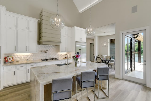 18 N Smith Loop N, Cleveland, TX 77327 - kitchen with stainless steel built in fridge, a sink, a chandelier, light wood finished floors, and high vaulted ceiling