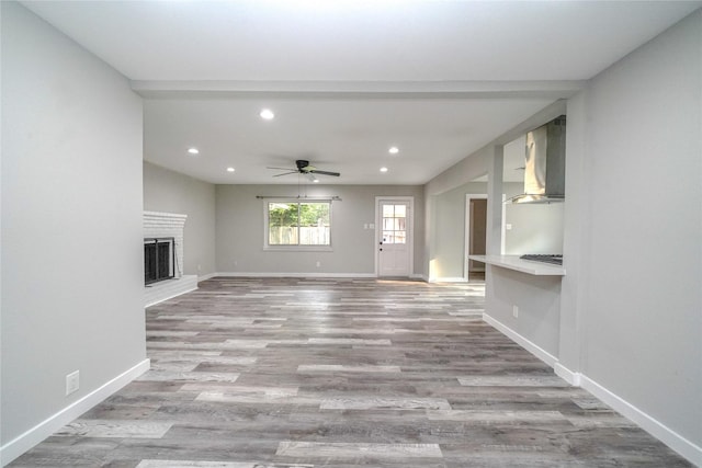 5915 Valkeith Dr, Houston, TX 77096 - unfurnished living room featuring recessed lighting, baseboards, wood finished floors, a ceiling fan, and a fireplace with raised hearth