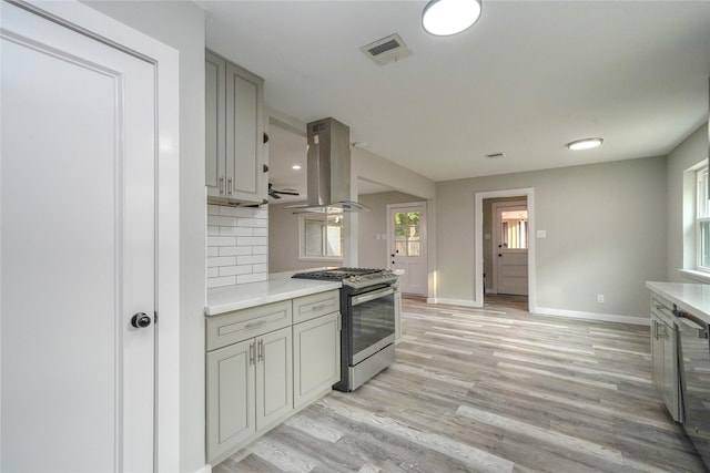 5915 Valkeith Dr, Houston, TX 77096 - kitchen with stainless steel gas range oven, island exhaust hood, baseboards, and light countertops