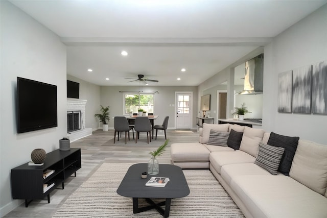 5915 Valkeith Dr, Houston, TX 77096 - living area with recessed lighting, baseboards, ceiling fan, light wood-style flooring, and a fireplace with raised hearth