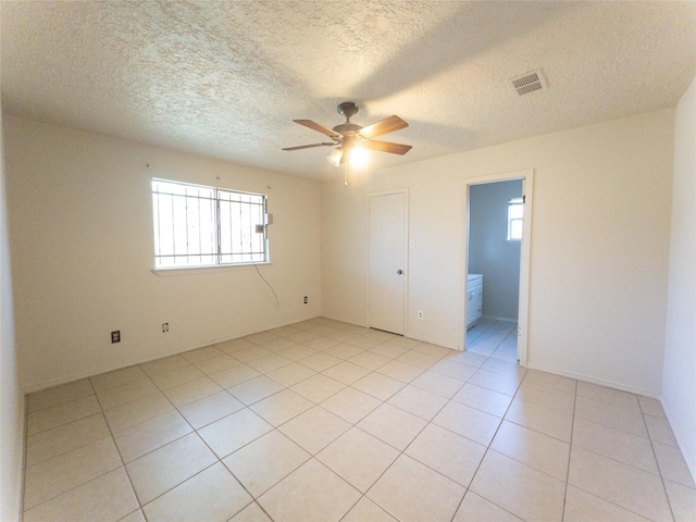2907 Helmsley Dr, Pearland, TX 77584 - empty room with ceiling fan, plenty of natural light, light tile patterned flooring, and a textured ceiling