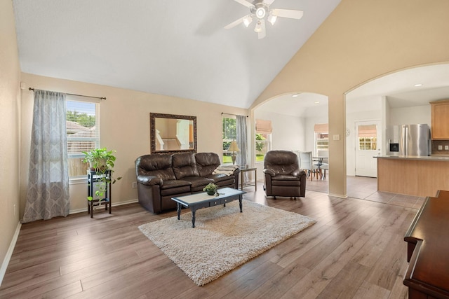 9226 Birch Springs Dr, Houston, TX 77095 - living area with arched walkways, a ceiling fan, light wood-style floors, baseboards, and high vaulted ceiling
