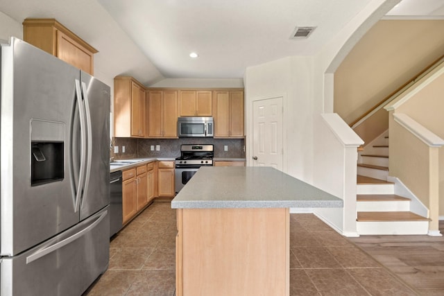 9226 Birch Springs Dr, Houston, TX 77095 - kitchen featuring appliances with stainless steel finishes, light brown cabinets, a center island, decorative backsplash, and tile patterned flooring