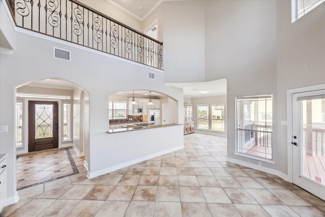 21 Fleming, Hitchcock, TX 77563 - entrance foyer featuring a high ceiling, light tile patterned floors, ornamental molding, baseboards, and arched walkways
