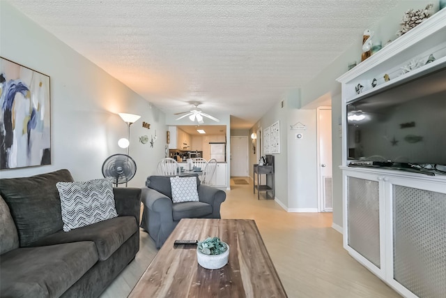7310 Seawall Blvd Unit 907, Galveston, TX 77551 - living room featuring a ceiling fan, light wood-type flooring, and a textured ceiling