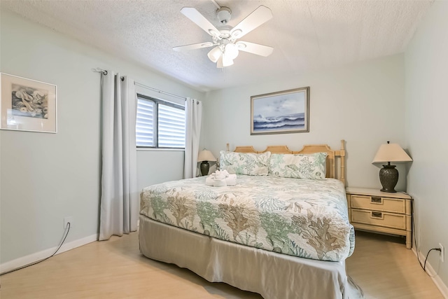 7310 Seawall Blvd Unit 907, Galveston, TX 77551 - bedroom with light wood finished floors, a textured ceiling, baseboards, and a ceiling fan
