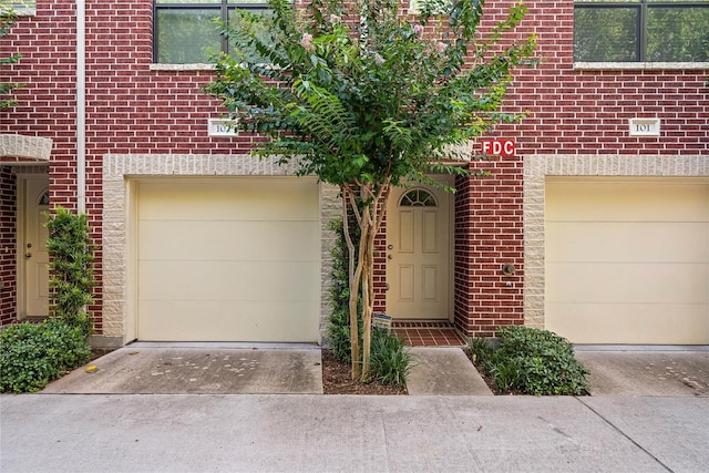8710 Beverlyhill St Unit 102, Houston, TX 77063 - view of front of property with concrete driveway, a garage, and brick siding