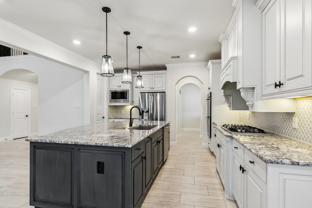 15411 Patten Forest Dr, Cypress, TX 77429 - kitchen featuring stainless steel appliances, arched walkways, a sink, white cabinets, and baseboards