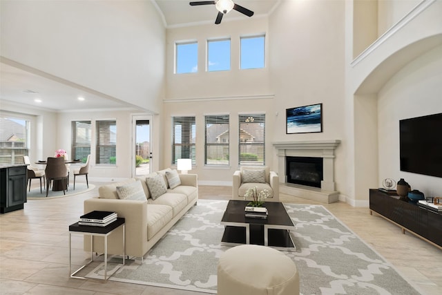 15411 Patten Forest Dr, Cypress, TX 77429 - living area with healthy amount of natural light, crown molding, ceiling fan, a glass covered fireplace, and baseboards