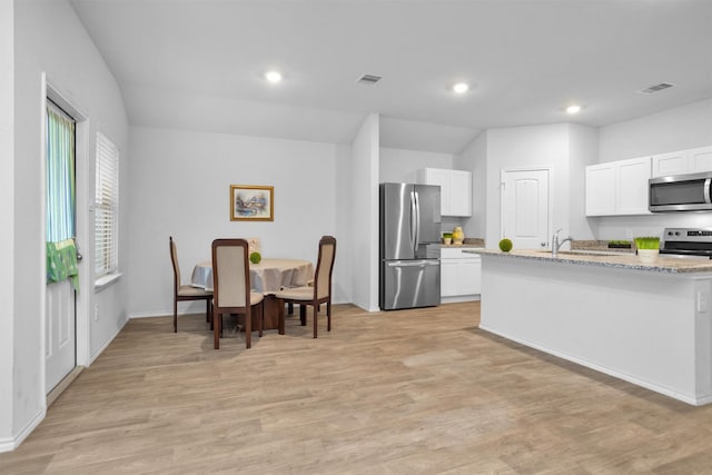 127 Barton Creek Dr, Huntsville, TX 77340 - kitchen with stainless steel appliances, white cabinetry, light wood-style floors, light stone countertops, and a sink