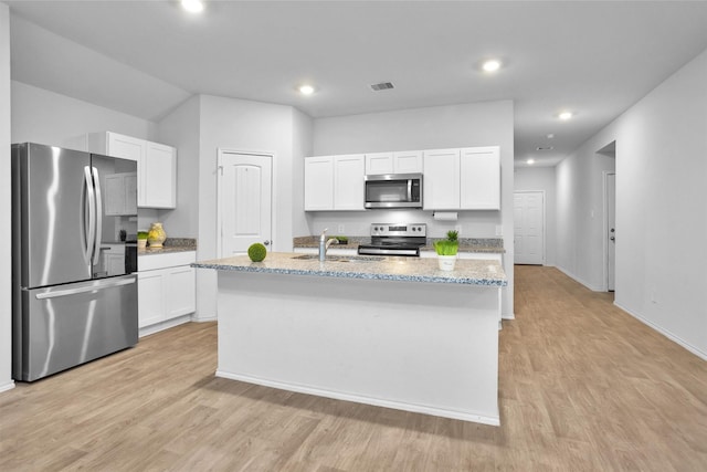 127 Barton Creek Dr, Huntsville, TX 77340 - kitchen with stainless steel appliances, light wood-style floors, white cabinets, a kitchen island with sink, and recessed lighting