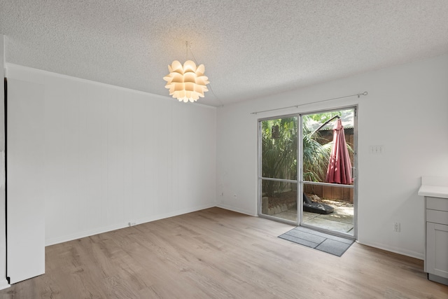 10320 Hammerly Blvd Unit 171, Houston, TX 77043 - unfurnished dining area with a textured ceiling, wood finished floors, baseboards, and a chandelier
