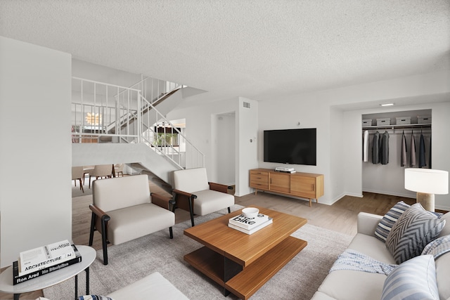 10320 Hammerly Blvd Unit 171, Houston, TX 77043 - living area with stairway, a textured ceiling, and wood finished floors