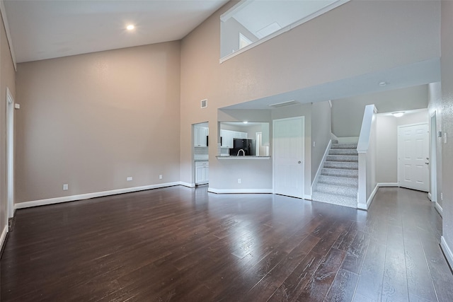 24214 Soft Pine Dr, Huffman, TX 77336 - unfurnished living room with dark wood finished floors, baseboards, stairs, and a towering ceiling