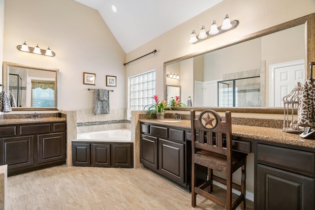 634 Carriage View Ln, Huffman, TX 77336 - full bathroom with a shower stall, two vanities, a garden tub, and high vaulted ceiling