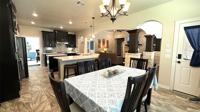 634 Carriage View Ln, Huffman, TX 77336 - dining space with arched walkways, light marble finish floors, a chandelier, recessed lighting, and decorative columns