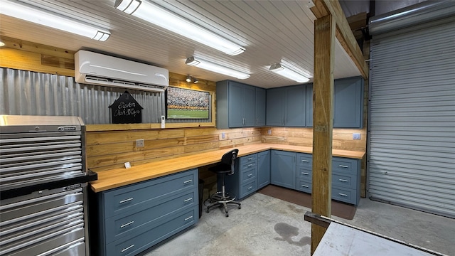 634 Carriage View Ln, Huffman, TX 77336 - office featuring concrete flooring, a wall mounted air conditioner, wooden walls, and built in study area