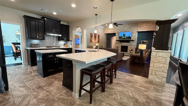 634 Carriage View Ln, Huffman, TX 77336 - kitchen with an island with sink, arched walkways, dark cabinets, ceiling fan, and recessed lighting