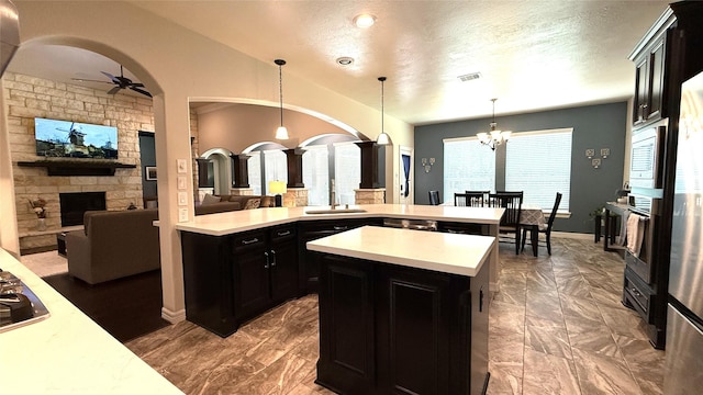 634 Carriage View Ln, Huffman, TX 77336 - kitchen featuring dark cabinetry, light countertops, dark marble finish floors, ceiling fan, and a textured ceiling
