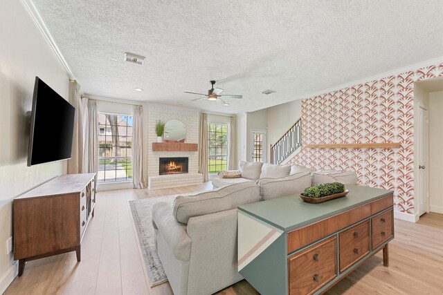 1017 Oak Knoll Ct, Sugar Land, TX 77498 - living room with plenty of natural light, a ceiling fan, a fireplace, a textured ceiling, and stairway
