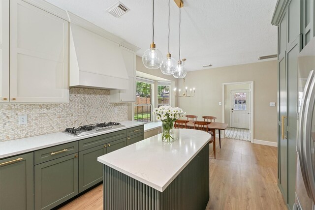 1017 Oak Knoll Ct, Sugar Land, TX 77498 - kitchen with green cabinets, appliances with stainless steel finishes, backsplash, light wood-type flooring, and light countertops
