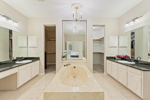 1017 Oak Knoll Ct, Sugar Land, TX 77498 - full bathroom with a chandelier, two vanities, a tub with jets, and a walk in closet