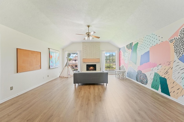 1017 Oak Knoll Ct, Sugar Land, TX 77498 - living room with a ceiling fan, a textured ceiling, wood finished floors, vaulted ceiling, and a brick fireplace