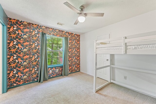 1017 Oak Knoll Ct, Sugar Land, TX 77498 - unfurnished bedroom featuring wallpapered walls, carpet flooring, baseboards, ceiling fan, and a textured ceiling