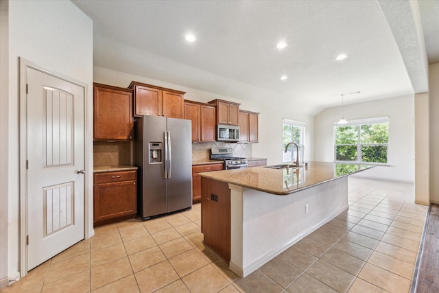 107 N Greenprint Cir, Tomball, TX 77375 - kitchen featuring stainless steel appliances, a sink, brown cabinets, tasteful backsplash, and an island with sink