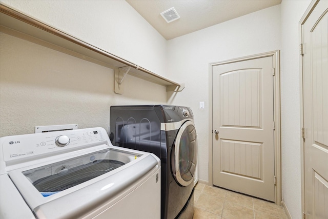 107 N Greenprint Cir, Tomball, TX 77375 - laundry room featuring independent washer and dryer, light tile patterned flooring, and baseboards
