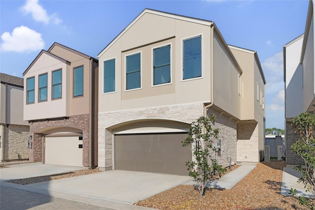 2933 El Fenice Ln, Houston, TX 77057 - view of front of property with stone siding, a garage, stucco siding, and concrete driveway
