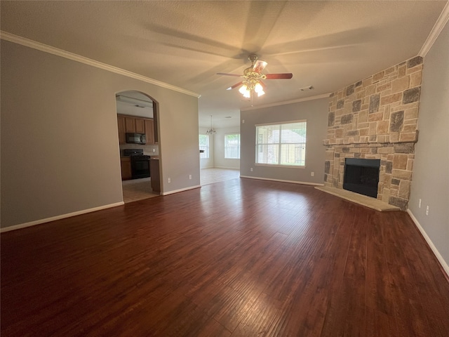 10208 Forest Spring Ln, Pearland, TX 77584 - unfurnished living room featuring a ceiling fan, ornamental molding, dark wood finished floors, a stone fireplace, and baseboards