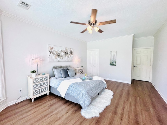 7210 Blenheim Palace Ln, Houston, TX 77095 - bedroom featuring wood finished floors, crown molding, a closet, baseboards, and a textured ceiling