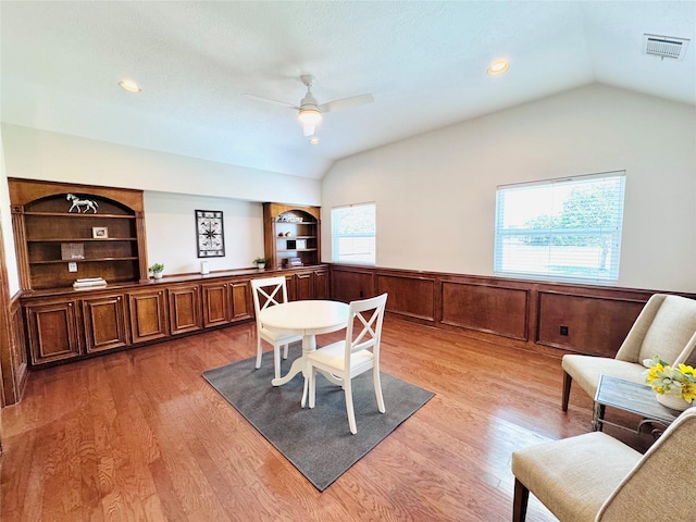 7210 Blenheim Palace Ln, Houston, TX 77095 - dining area featuring lofted ceiling, ceiling fan, wainscoting, light wood-style flooring, and built in shelves