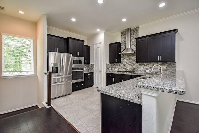 2213 Bellefontaine St, Houston, TX 77030 - kitchen with stainless steel appliances, a sink, wall chimney exhaust hood, a peninsula, and light stone counters