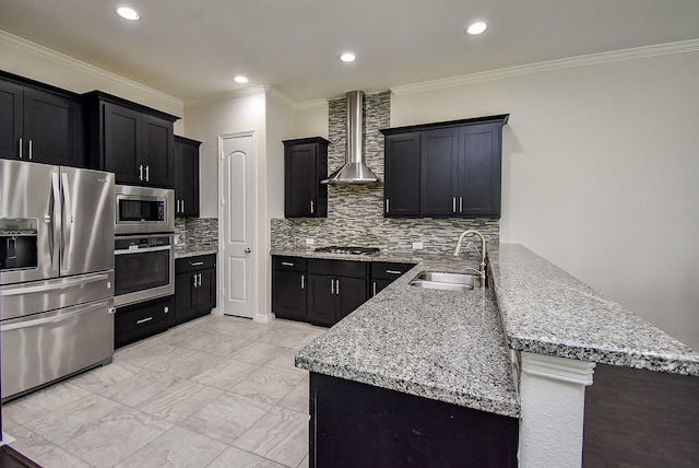 2213 Bellefontaine St, Houston, TX 77030 - kitchen with stainless steel appliances, wall chimney exhaust hood, a sink, a peninsula, and decorative backsplash