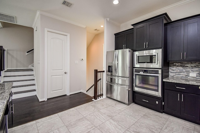 2213 Bellefontaine St, Houston, TX 77030 - kitchen featuring appliances with stainless steel finishes, ornamental molding, light stone counters, backsplash, and dark cabinets