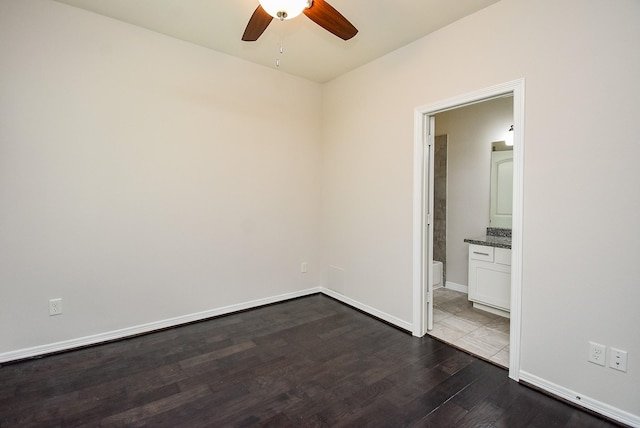 2213 Bellefontaine St, Houston, TX 77030 - empty room with dark wood-style flooring, a ceiling fan, and baseboards