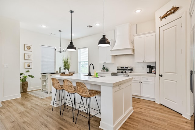 2515 103rd St, Galveston, TX 77554 - kitchen with custom exhaust hood, electric stove, a sink, light wood-type flooring, and recessed lighting