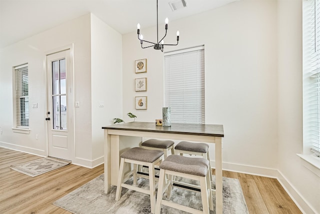 2515 103rd St, Galveston, TX 77554 - dining area with wood finished floors, a chandelier, and baseboards