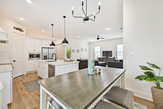 2515 103rd St, Galveston, TX 77554 - dining area with light wood-type flooring, a chandelier, ceiling fan, recessed lighting, and baseboards
