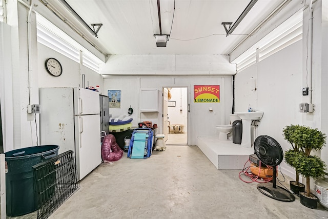 2515 103rd St, Galveston, TX 77554 - garage featuring freestanding refrigerator and a garage door opener
