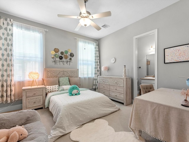 16819 Himley Dr, Cypress, TX 77433 - carpeted bedroom with multiple windows, ensuite bathroom, and a ceiling fan